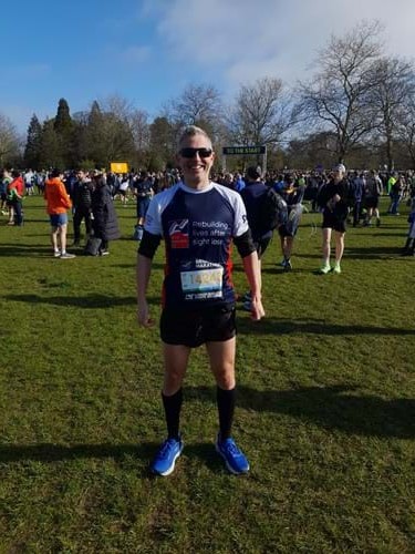Stuart stood in a field with fellow runners behind him
