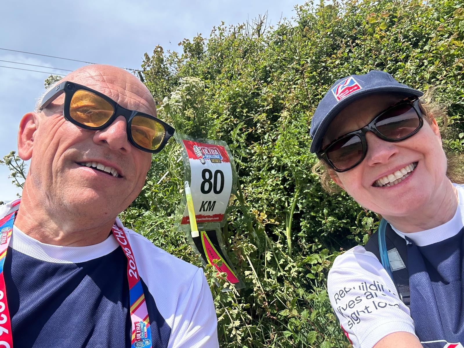 A selfie taken at the 80km marker. Jerry and Anne are smiling with the marker behind them.