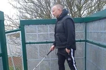 Ian is pictured about to head down a ramp with his white cane