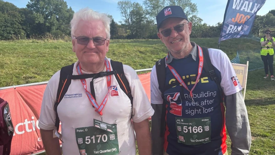 Peter and Jez in Blind Veterans UK T-shirts and Peter holding his white cane