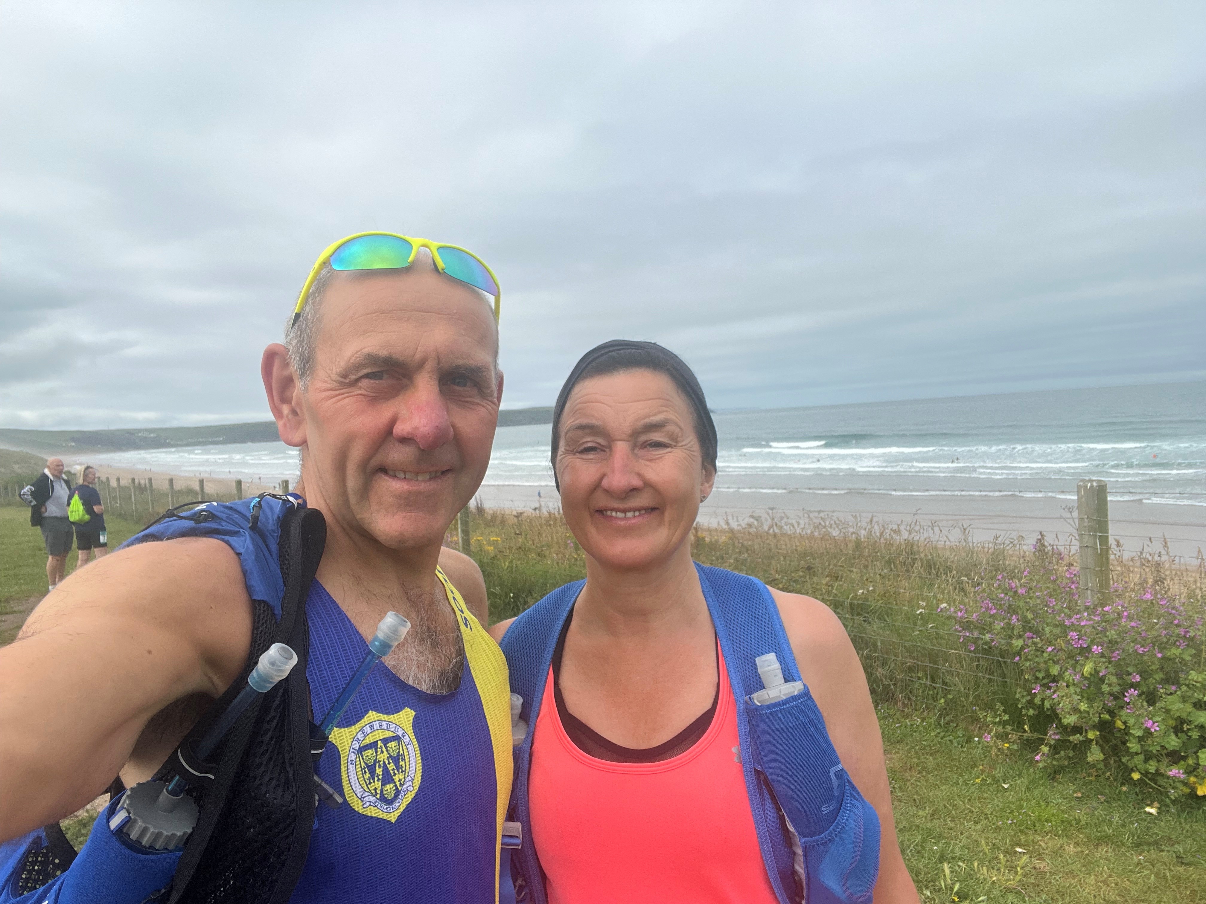 Kathryn and Simon by the coast on a very grey day have stopped for a photo during a training run
