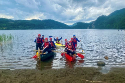 Blind veteran Jules and a group of blind veterans and guides, pictured in their canoes in a lake as the moor up to shore.