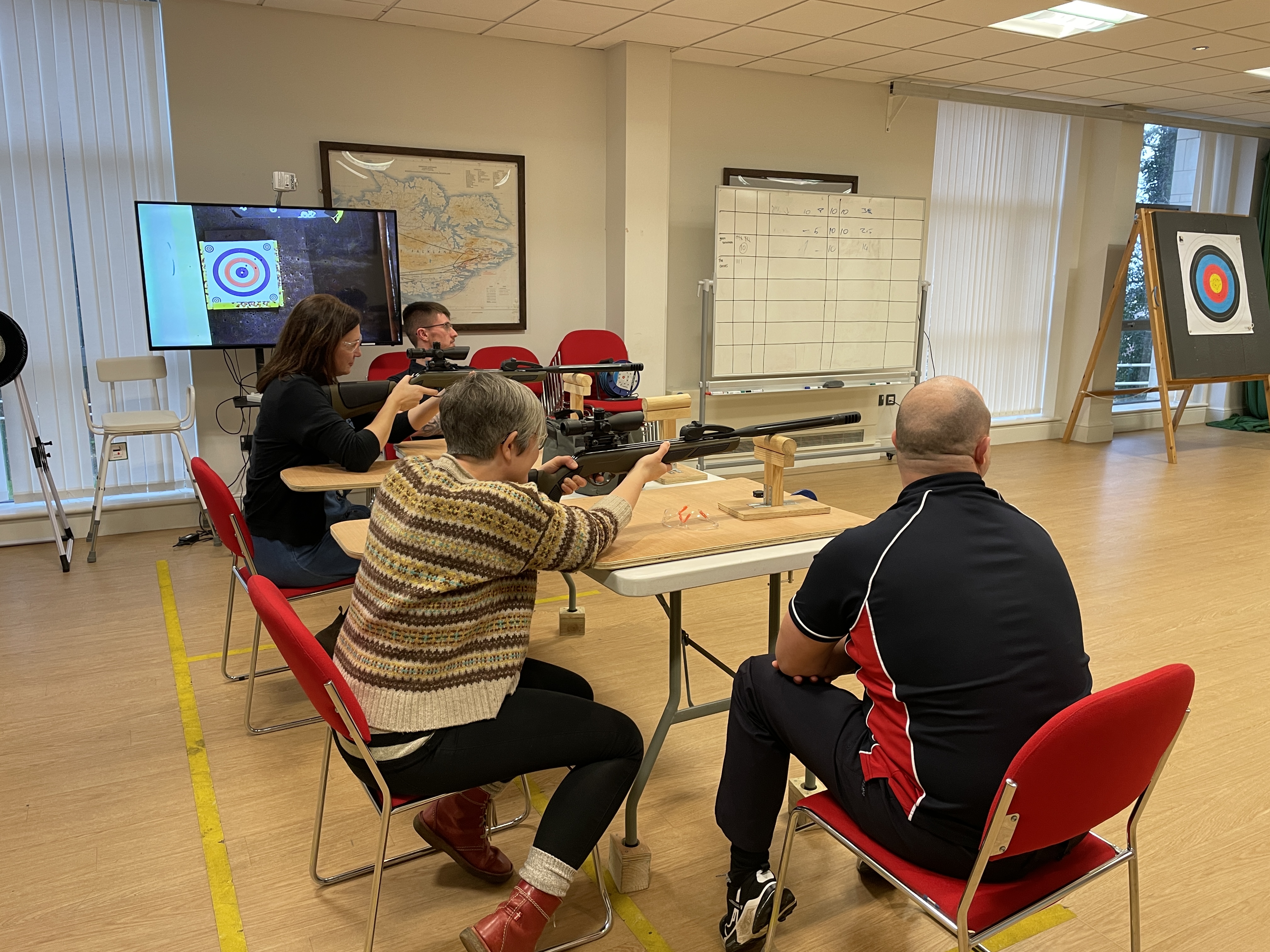 Two ladies and two members of Blind Veterans UK staff at the air rifle range