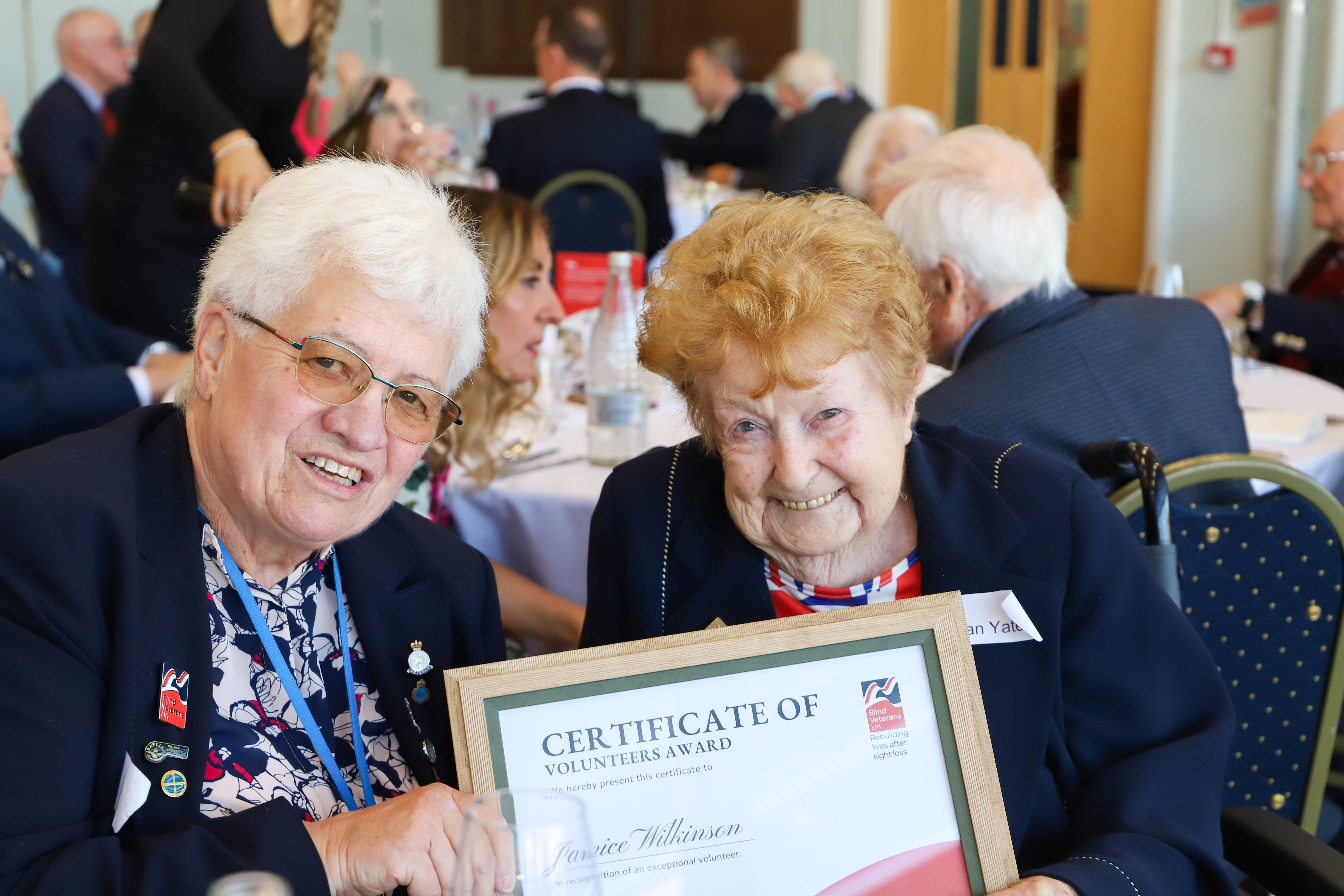 Volunteer Janice (left) and blind veteran Vivian (right) holding Janice's Founders Award.