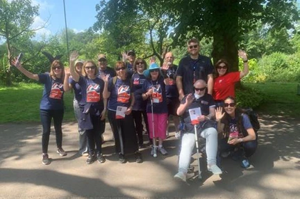 A group shot of all the walkers who took part taken outside under a tree