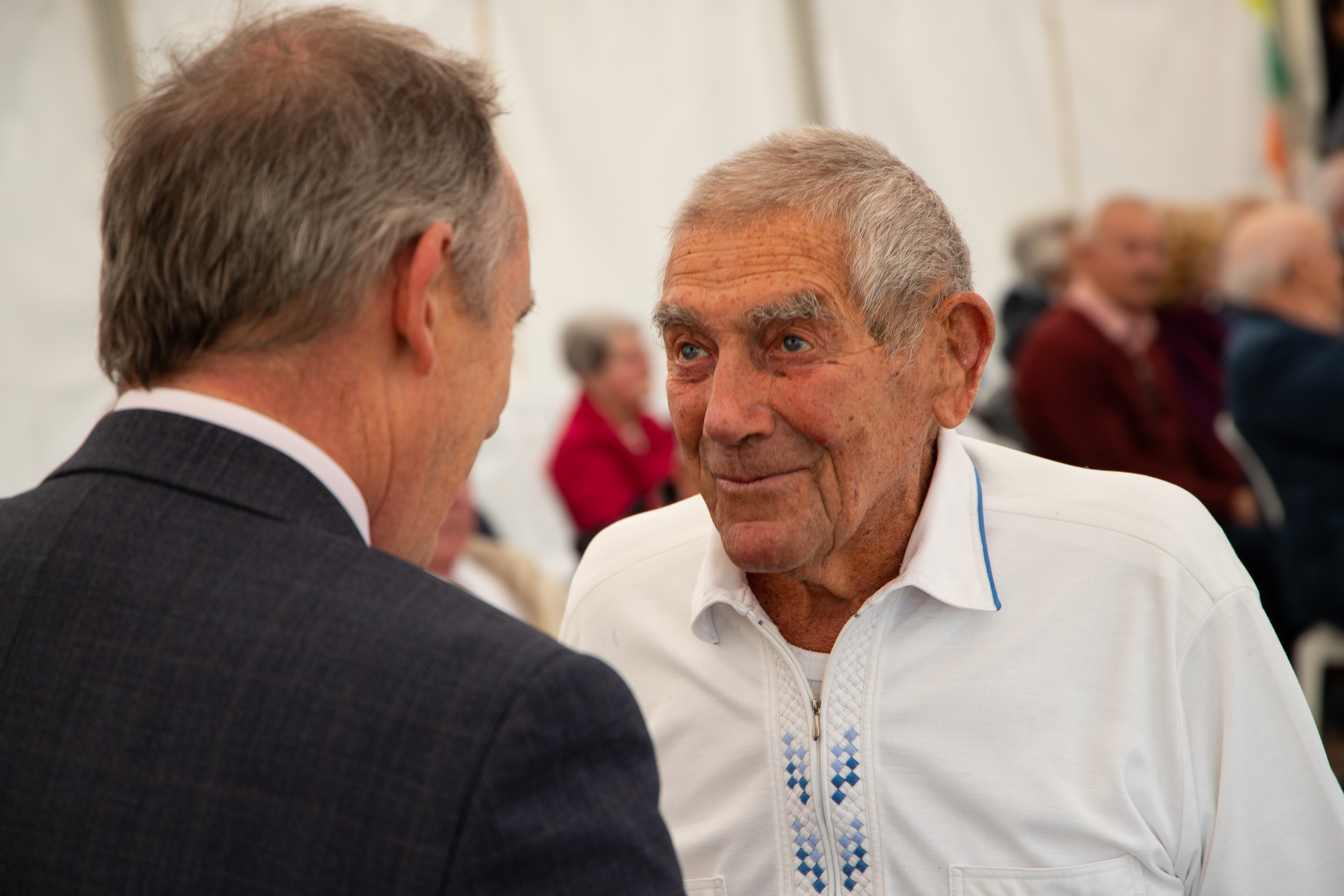 Blind veteran Eddie smiling as he listen to Nick Caplin speak