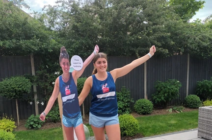 Evie wearing a Blind Veterans UK vest standing next to a cardboard cut-out of herself