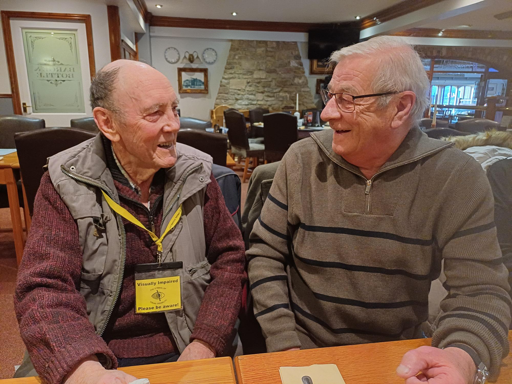 Dave and Terry are seated, smiling as they are engaged in conversation.
