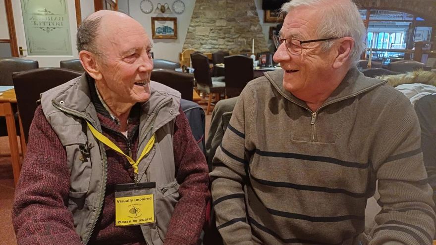 Dave and Terry are seated, smiling as they are engaged in conversation.