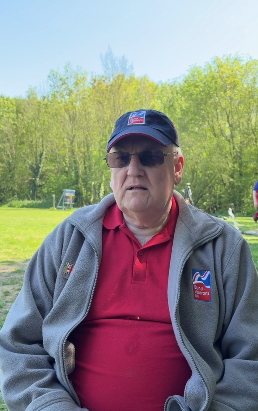 Peter in a Blind Veterans UK baseball cap and fleece and wearing sunglasses