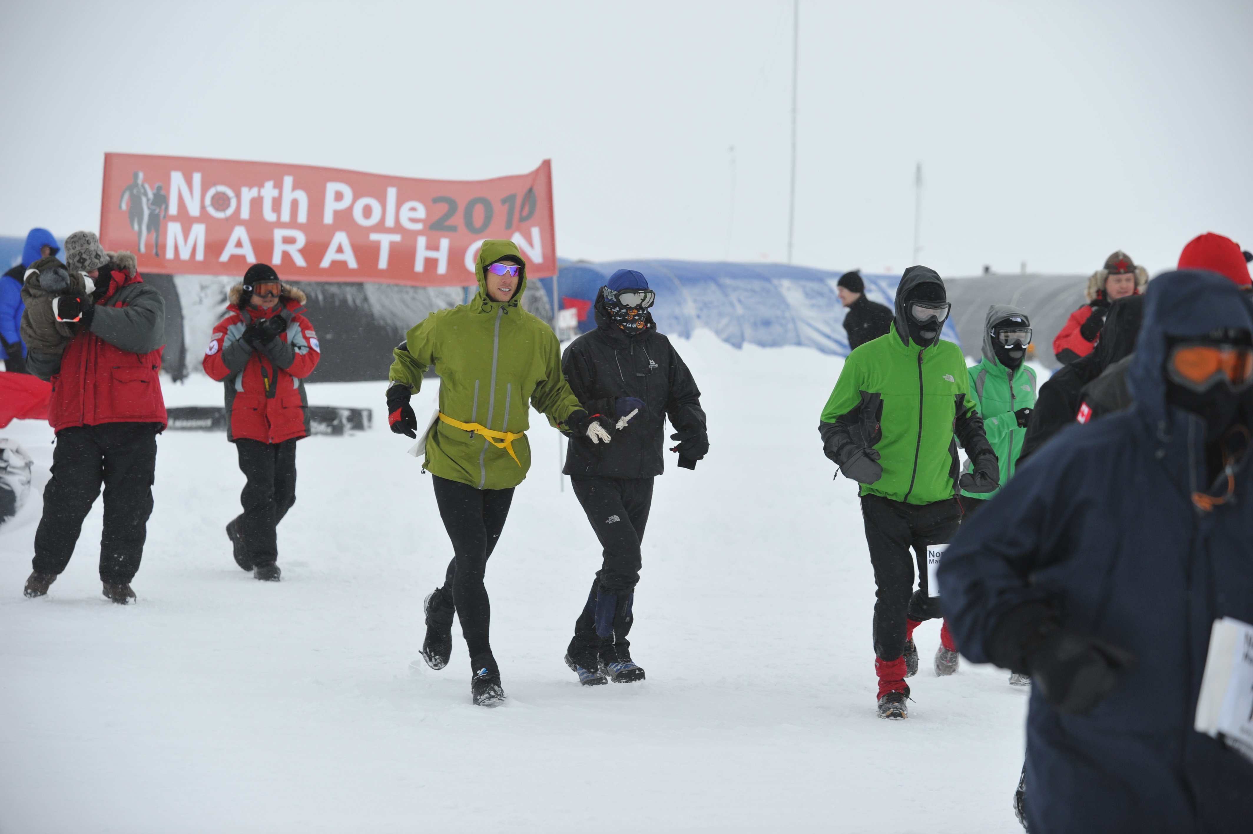 Jamie and his guide runner run next to eachother on the snow, wearing their winter jackets