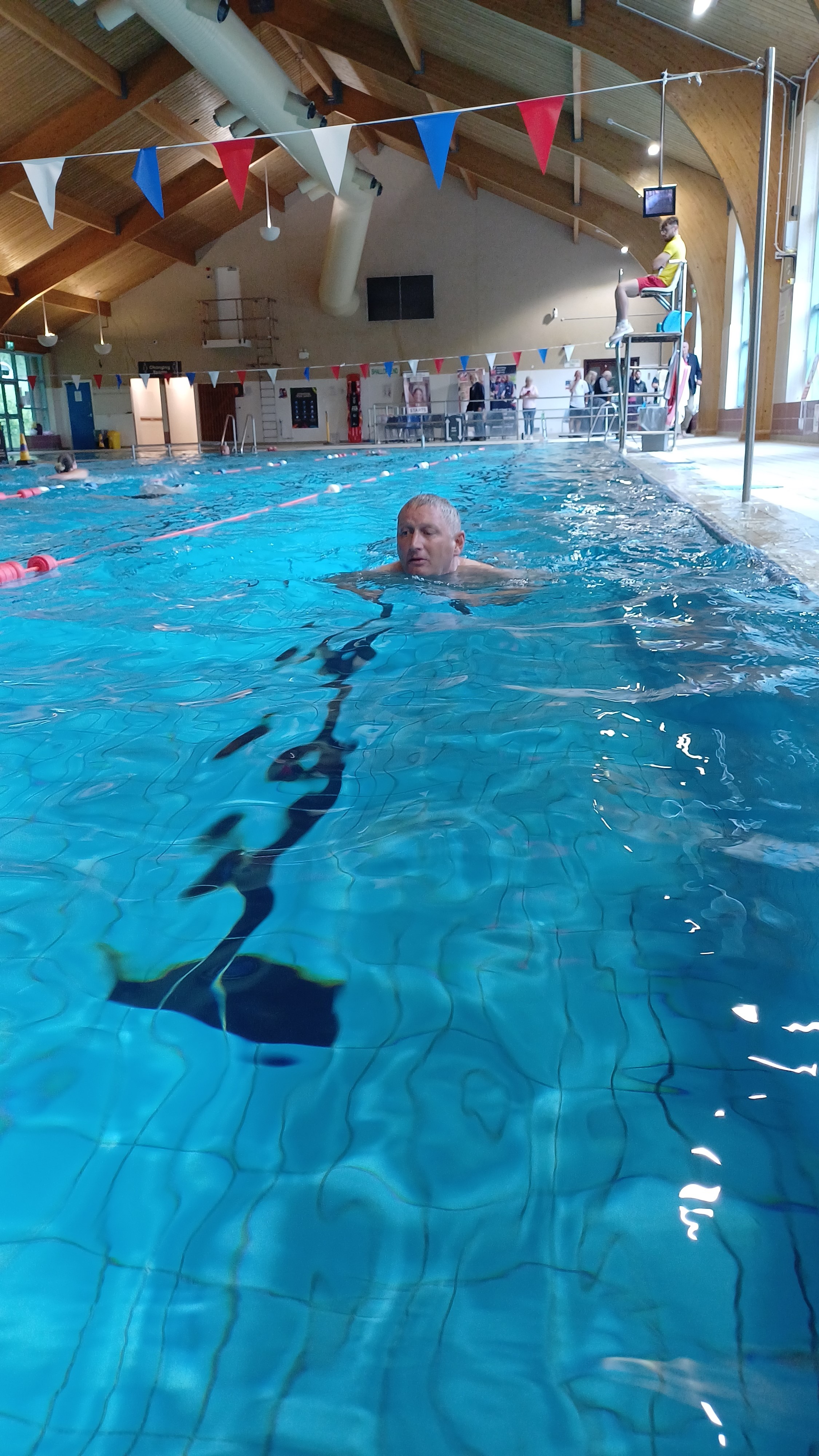 Lee half way down the pool doing breast stroke