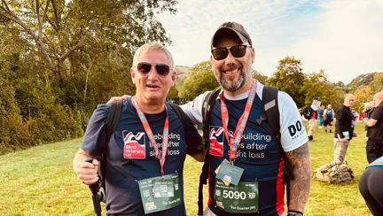 Lee and Aaron standing side by side smiling