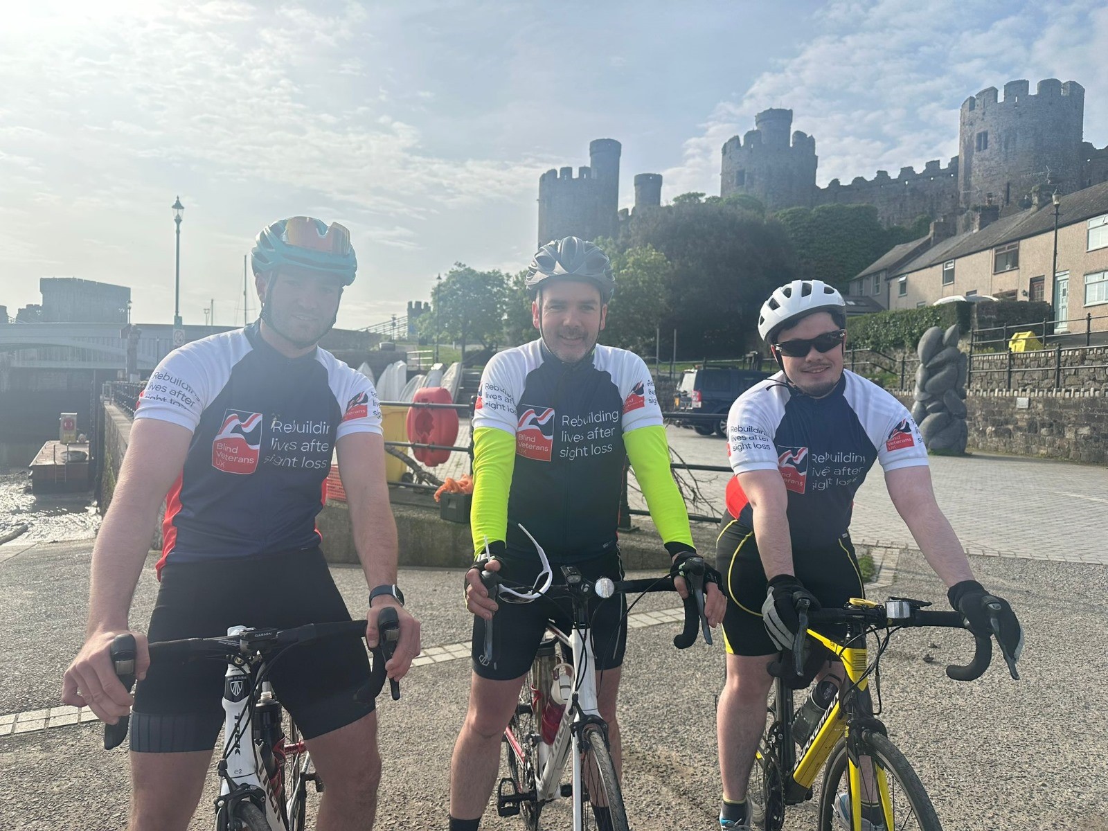The three cyclists on their bikes with Conwy Castle in the background