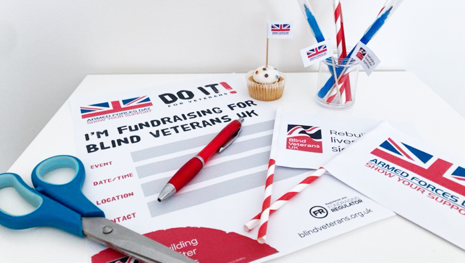 A selection of our Armed Forces Month resources featuring the logos of Blind Veterans UK and National Armed Forces Day, displayed alongside scissors, glue and colouring pens.