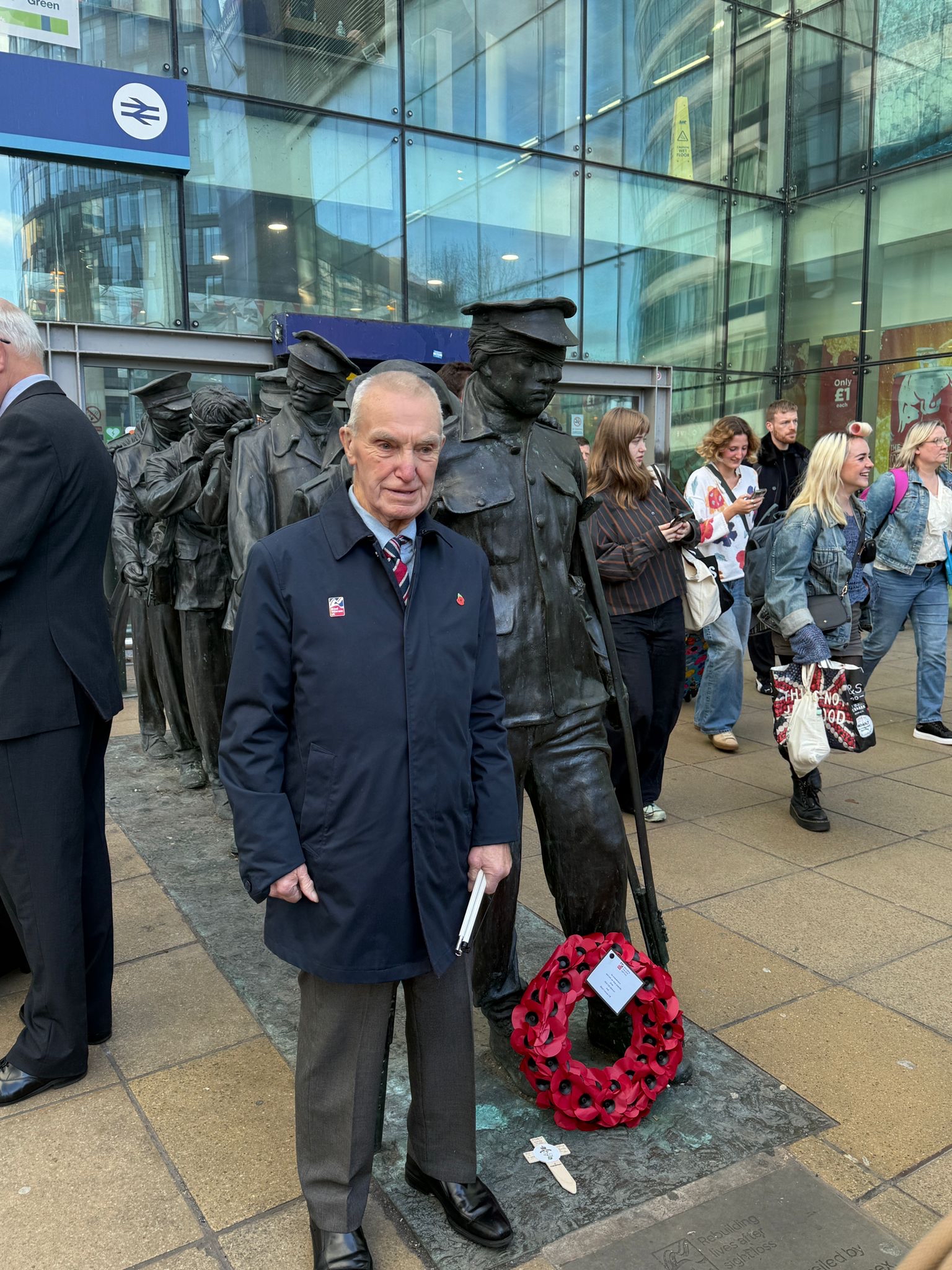 Ken stands next to the Victory over Blindness statue which has a wreath in front of it that he had laid