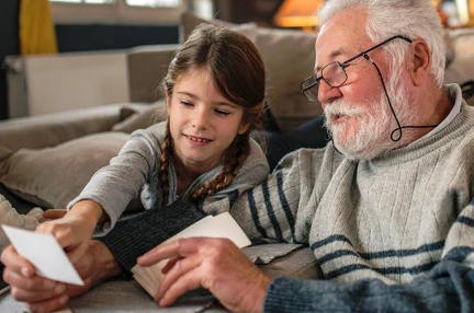 A grandad showing his granddaughter memories from past