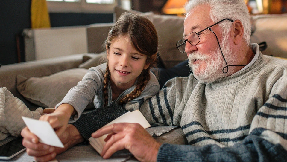 A grandad showing his granddaughter memories from past