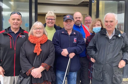 Photo of our Member design group featuring blind veterans and staff pictured outside the new wellbeing centre in Rustington