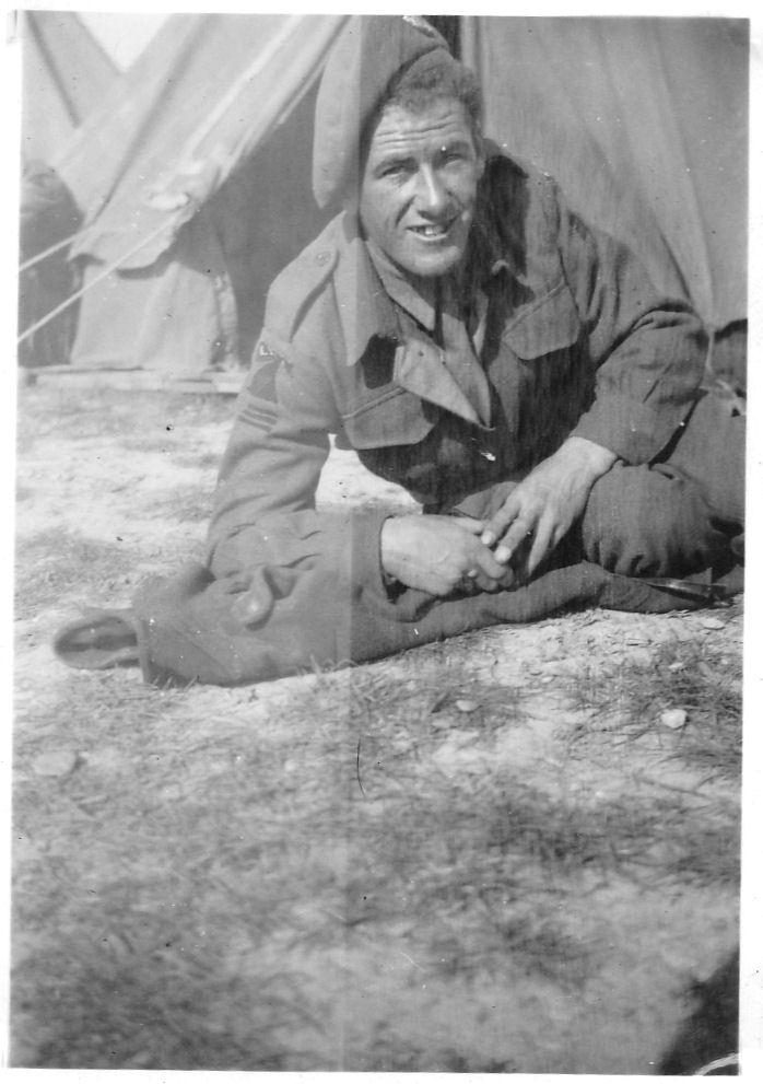 A young Harry, pictured in the 1940s wearing his military uniform, seated casually outside a tent.