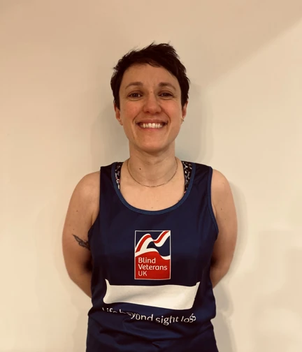 Ettie in her Blind Veterans UK running top with a wide smile