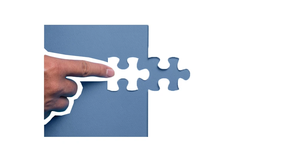 A photo of a hand placing the final jigsaw puzzle piece