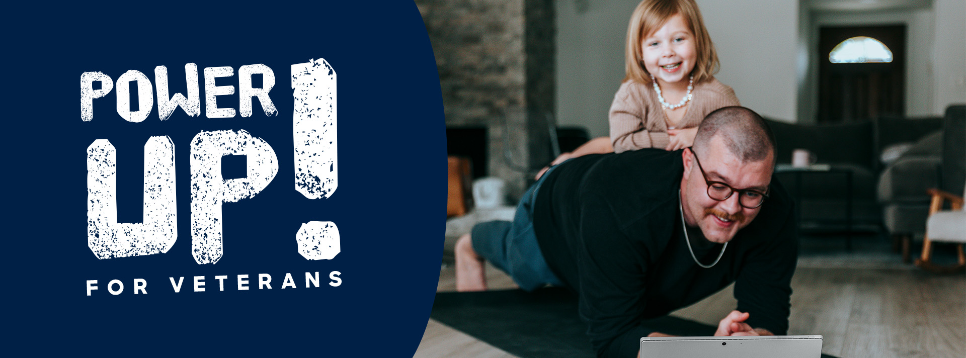 A supporter planking and laughing with his young daughter leaning on him