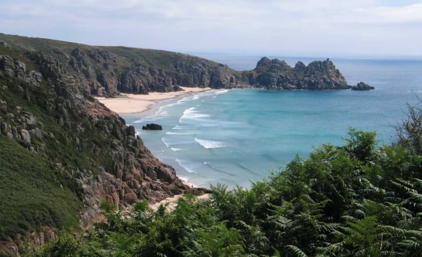 Porthcurno Beach surrounded by high cliffs