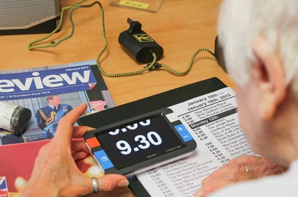 Photo of blind veteran Janet be trained to use a magnifier