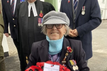 Nancy sat in her wheelchair holding a wreath