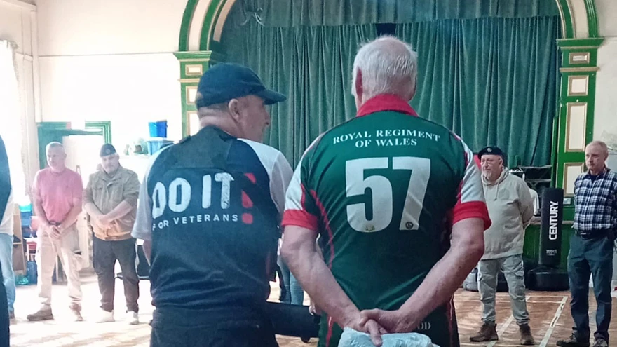A picture of the back of Tony and Dai standing inside a large hall