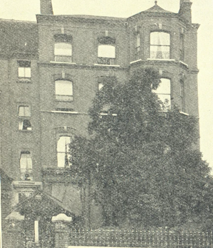 A historic photograph of a muti-story building in Bayswater Hill, London. The building features large windows and a grand entrance, partially covered by overgrown foliage.