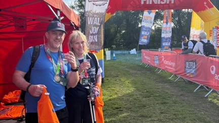 Jill and her guide Phil at the finish with a glass of prosecco