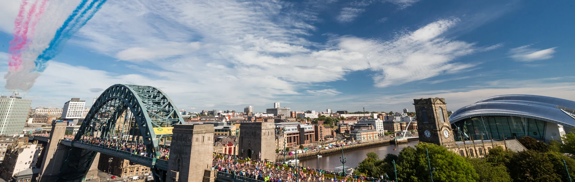A wide shot of the Red Arrows fly over Tyne Bridge as part of Great North Run 2015