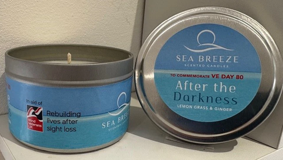 A finished After the Darkness candle. The candle sits inside a metal tub and the lid has been removed and is next to the candle so that the labels can clearly be seen.