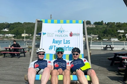 The three lads sat in a giant deckchair on Bangor Pier