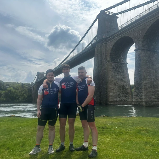 James stood with his arms around Tom and Aled in front of Menai Bridge