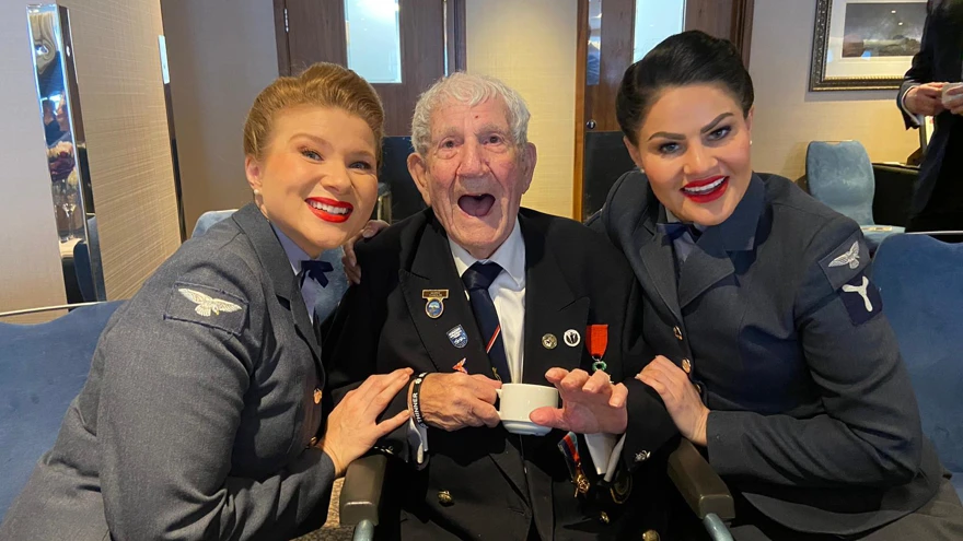 Blind D-Day veteran George sitting with two D-Day darling singers at our D-Day 80 event in London