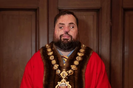 Blind veteran Simon in his red mayoral robe and gold chain