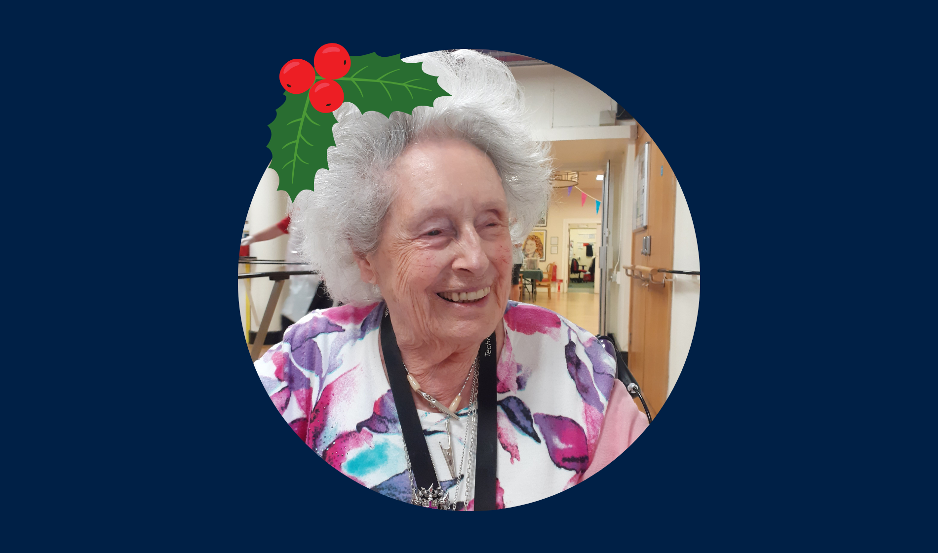 Blind veteran Rosalie wearing a Christmas hat, detailed with an illustration of holly.
