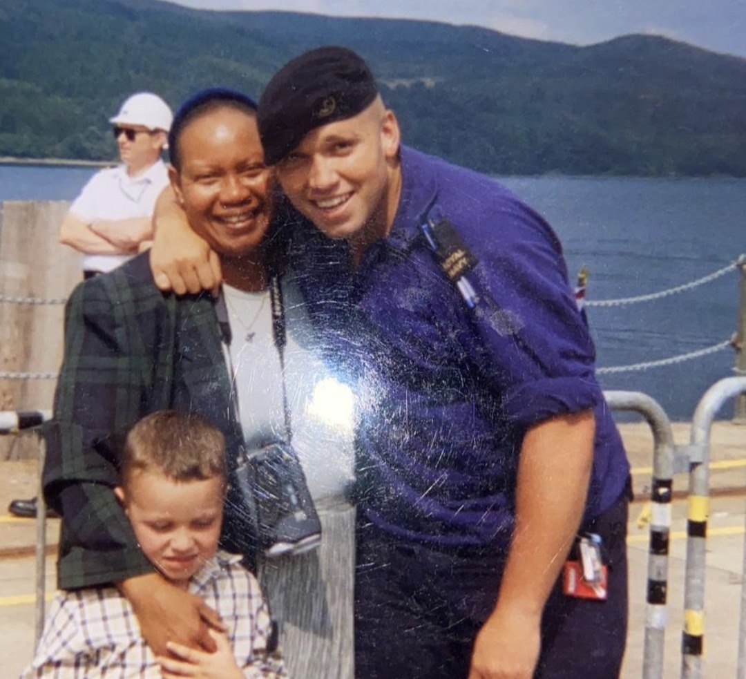 Herbie in uniform with his mother on a boat with mountains in the background