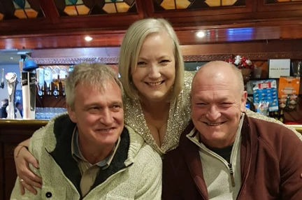 Christine stood between her two brothers and all three are smiling widely