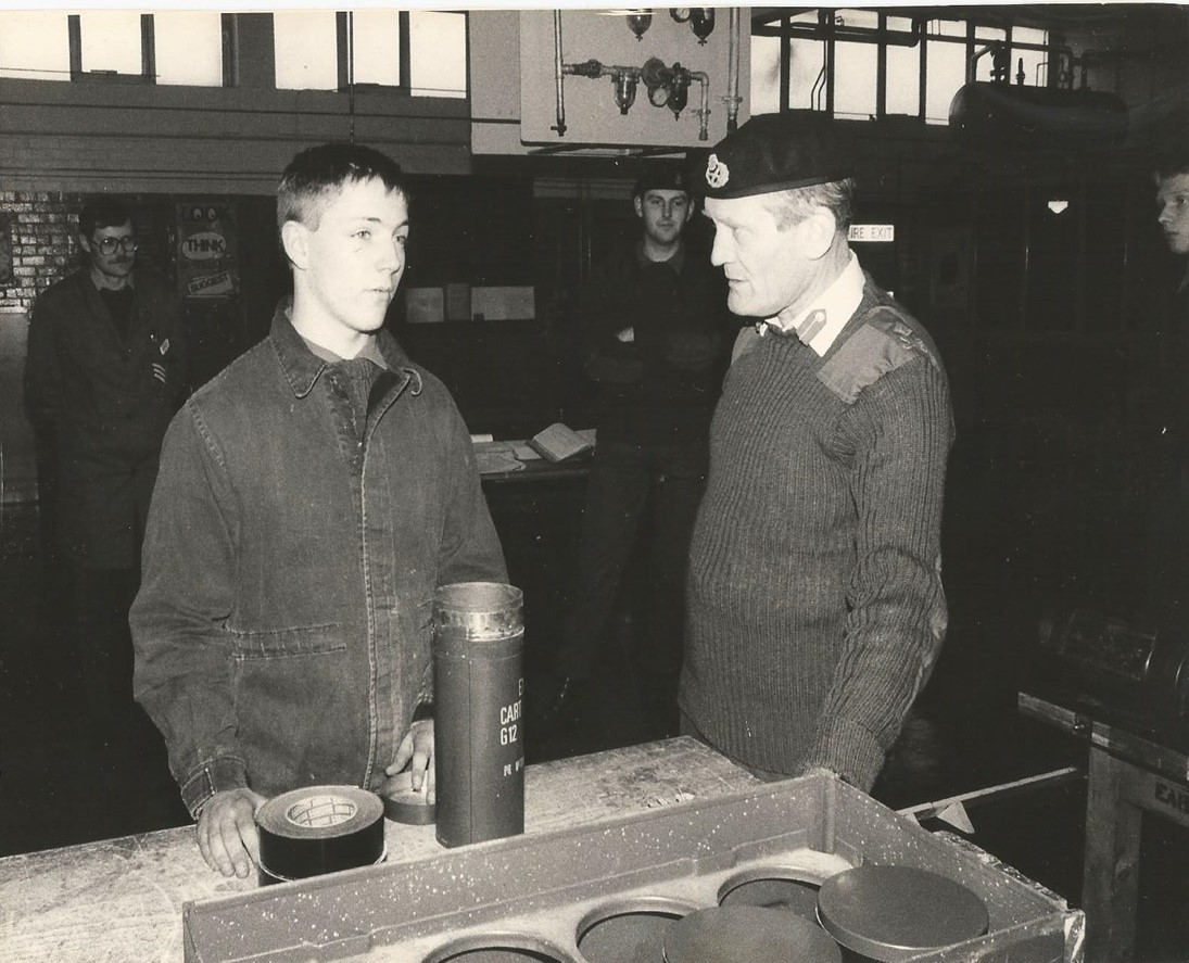 A black and white picture of Chris wearing overalls while at work 