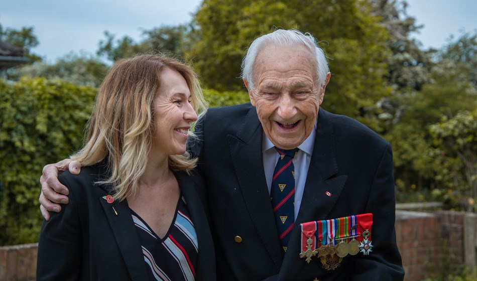 Blind veteran Ron wearing his military badges and laughing with care worker Kirsty