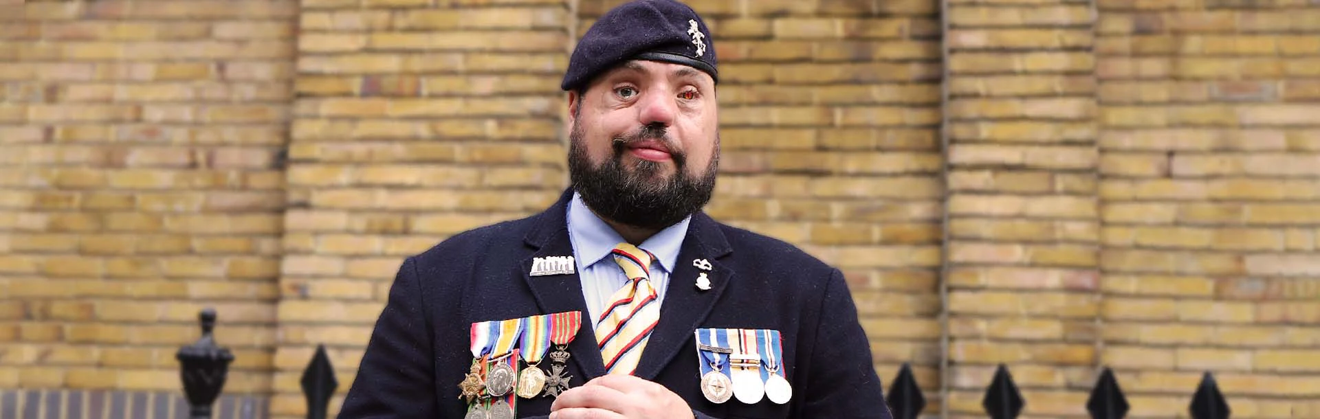 Photo of blind veteran Simon wearing his service medals
