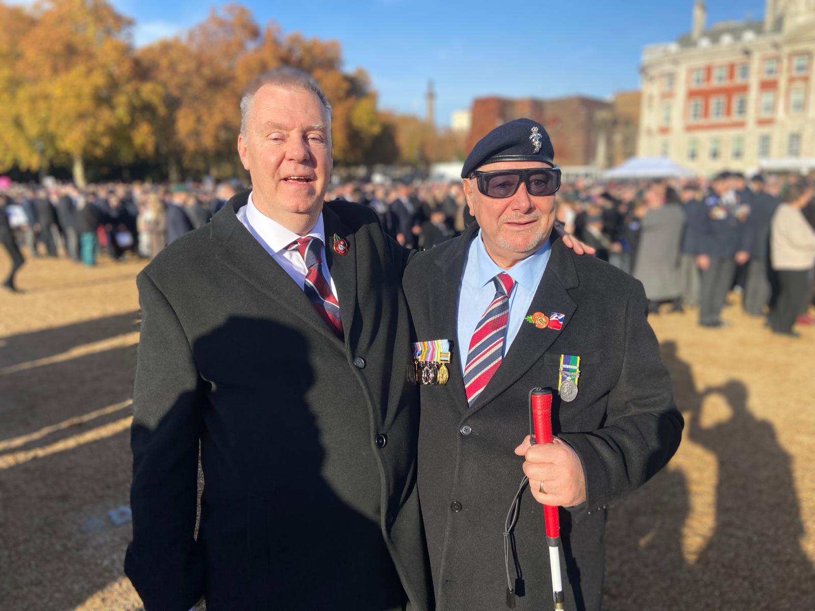 Blind Veterans Bob and Peter standing arm in arm in Horse Guards Parade for remembrance 25