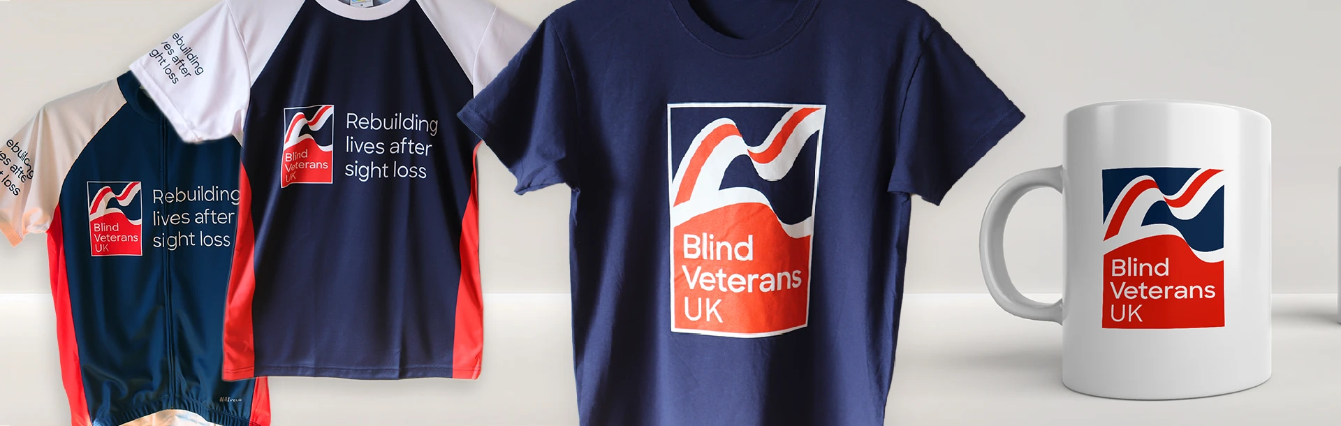 A variation of Blind Veterans UK branded t-shirts and a mug