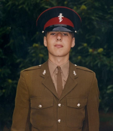 A young Simon standing proudly in his Army uniform