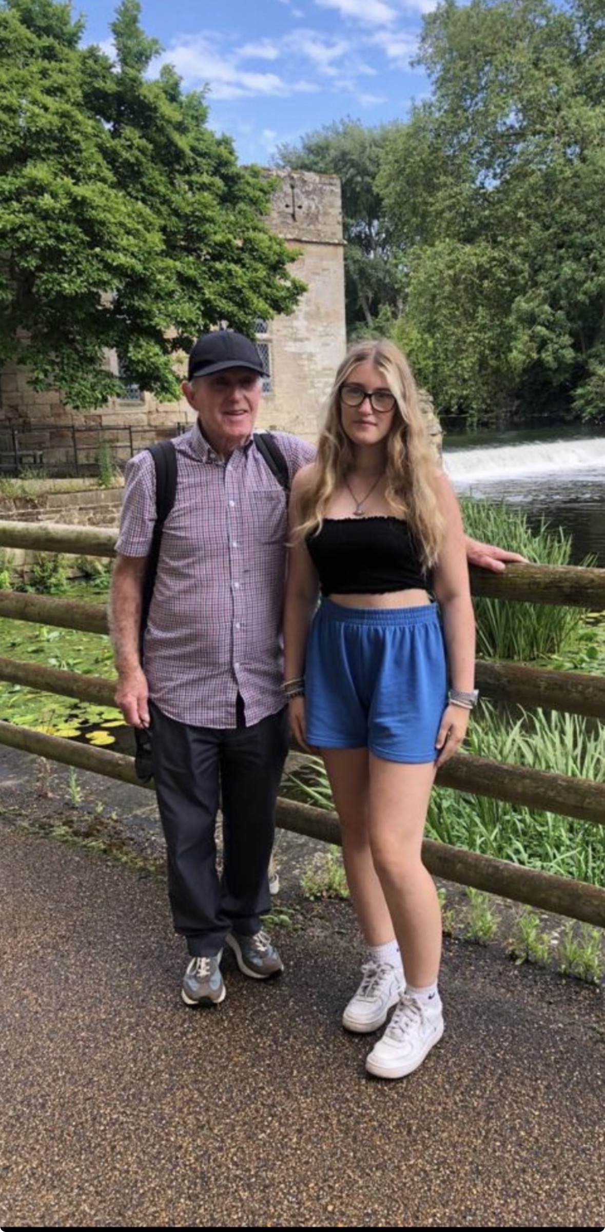 John and Lilly are outside on a warm day stood in front of an old church during one of their walks together. 
