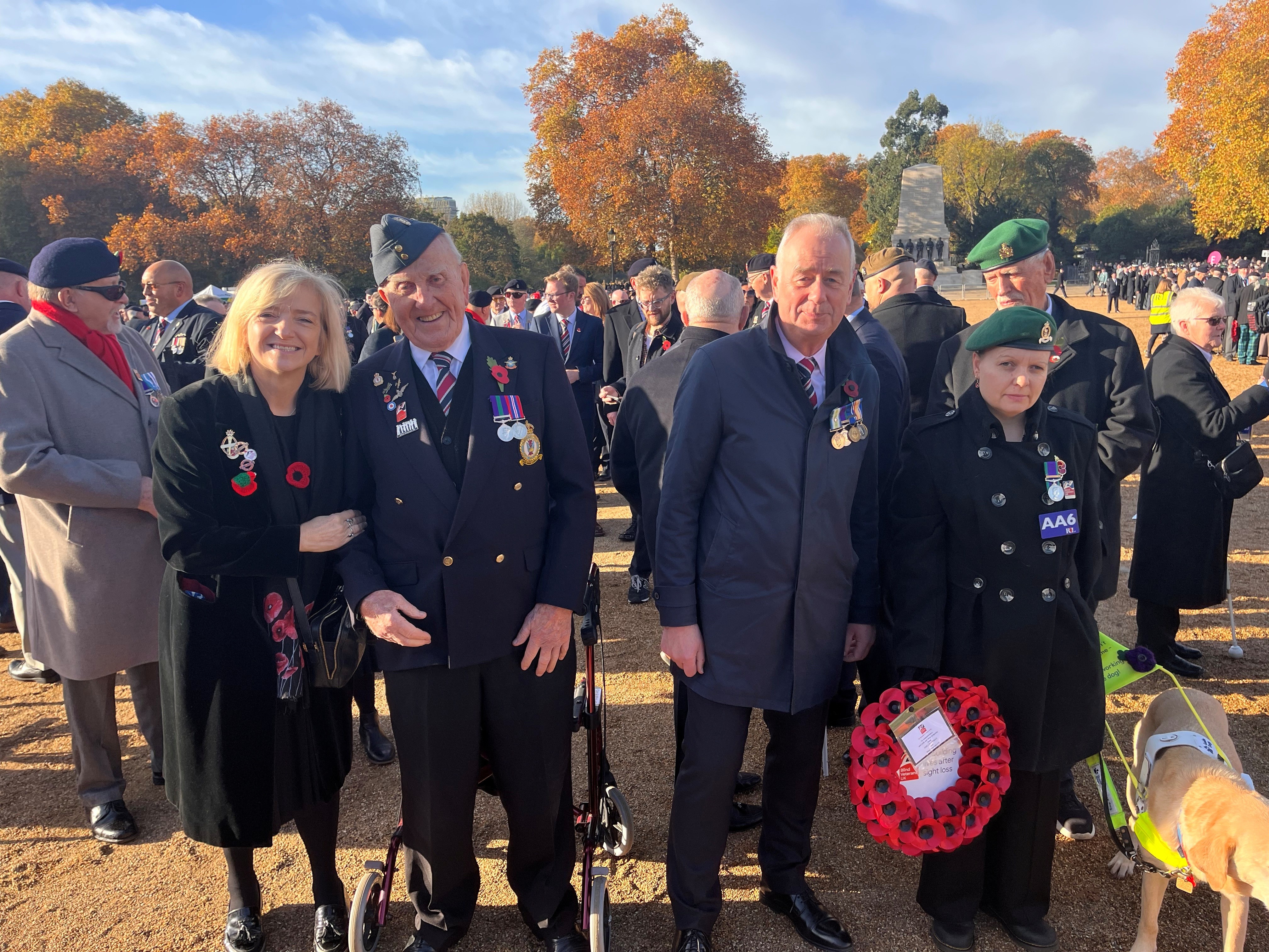 Glynis stands on Horse Guards Parade alongside the Chief Executive and two veterans, she is wearing a poppy